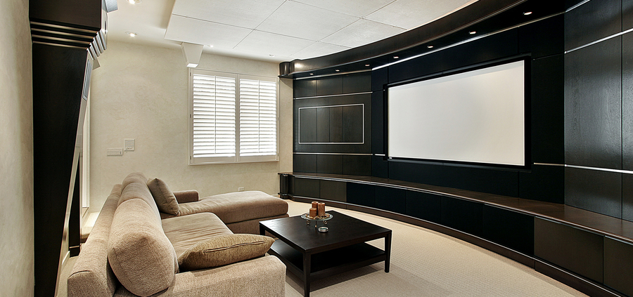 a media room with a curved TV wall with brown sofas